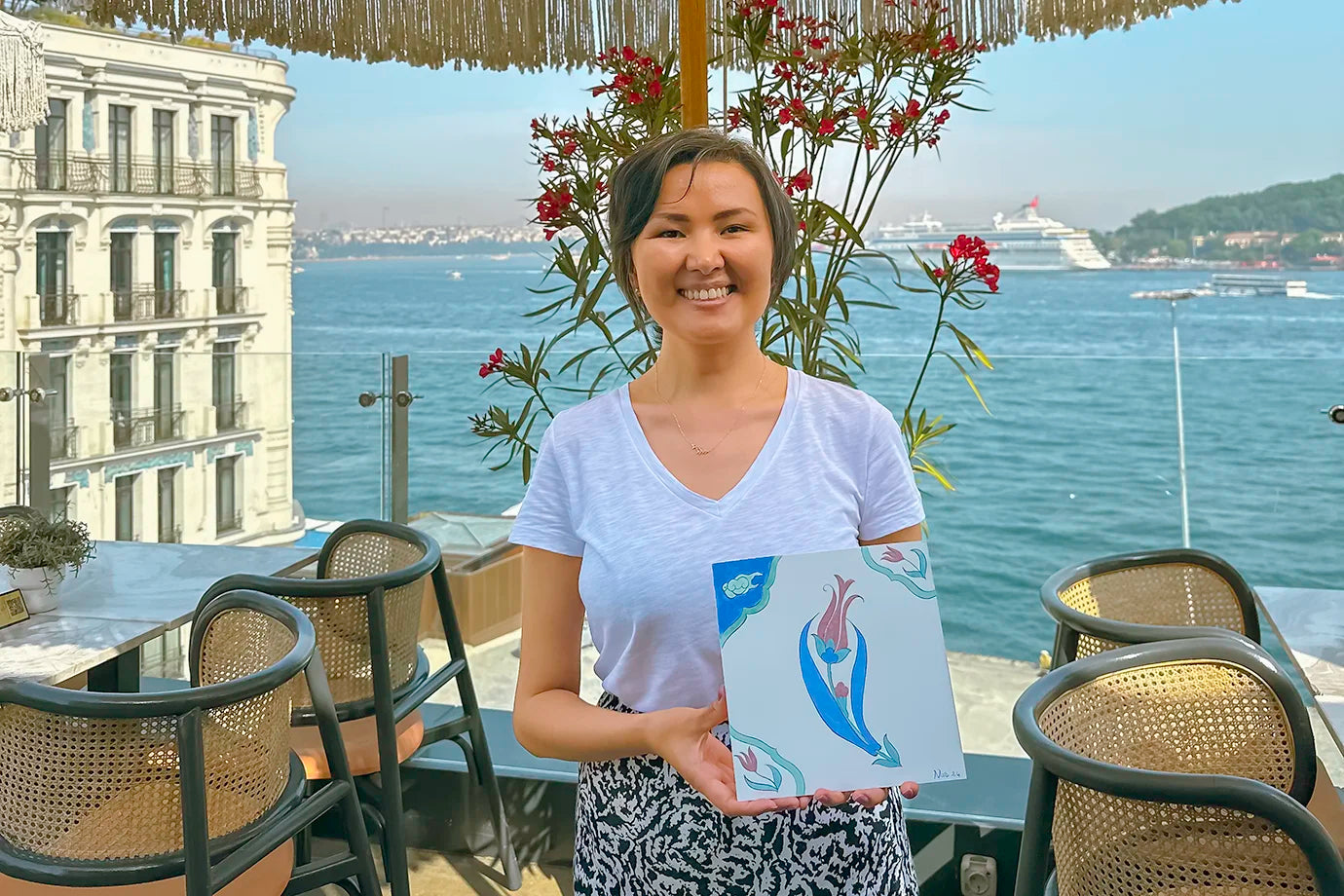 Woman showing ceramic decor and posing with Bosphorus view 
